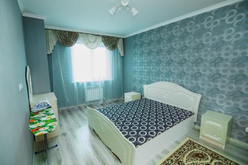 - une chambre avec un lit blanc et une fenêtre dans l'établissement Apartments on 7/1 Sarayshyq, à Astana