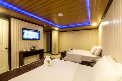 a hotel room with two beds and a tv at Diamond Water Edge Resort in Boracay