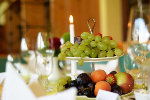 a plate of grapes and other fruit on a table at Nashira Kurpark Hotel in Bad Herrenalb