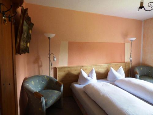 a hotel room with two beds and a chair at Bäckeralm© - B&B 16 + in Mittenwald
