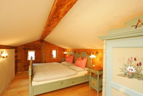 a bedroom with a bed and a wooden ceiling at Das Baderhaus in Zell am See