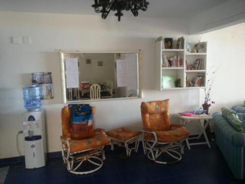 a living room with two chairs and a window at Riviera Dream Chalet in Dawwār al Ḩajj Aḩmad