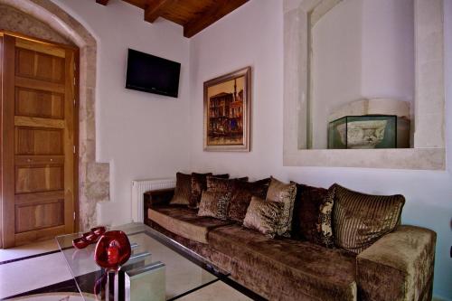 a living room with a brown couch and a door at Bellagio Luxury Boutique Hotel in Rethymno Town