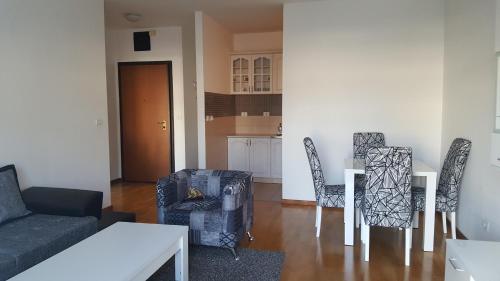 a living room with a couch and a table and chairs at Zebra in Podgorica