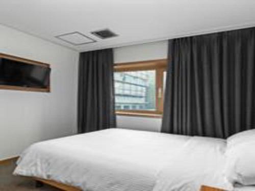 Ένα ή περισσότερα κρεβάτια σε δωμάτιο στο Busan Tourist Hotel