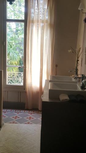 - une chambre avec 2 lits et une fenêtre avec un lavabo dans l'établissement Manoir en Crau, à Arles