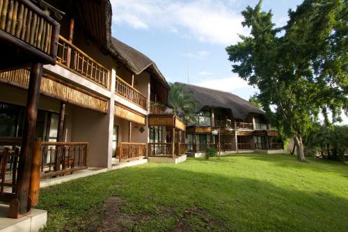 an exterior view of a building with a grass yard at Cresta Mowana Safari Resort & Spa in Kasane