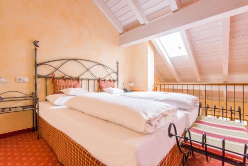 two beds in a bedroom with a large window at Hotel und Landgasthof Altwirt in Großhartpenning