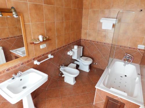 y baño con aseo, lavabo y bañera. en Hotel Rustico Casa Do Vento en Baio