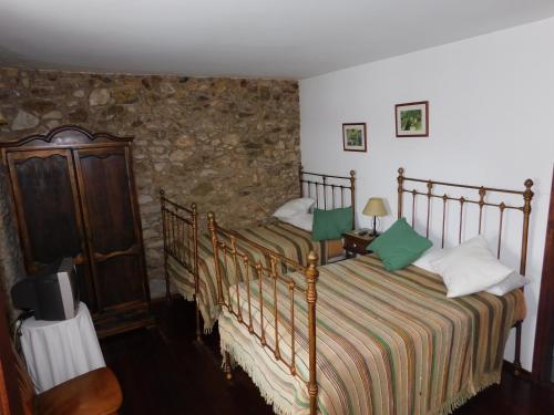 a bedroom with a bed and a tv in a room at Hotel Rustico Casa Do Vento in Bayo