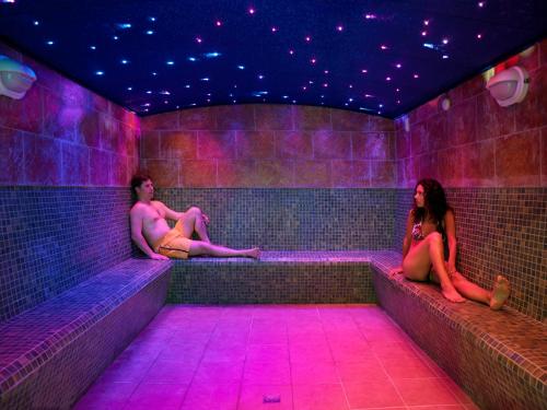 three people sitting in a room with purple lights at Golden Port Salou & Spa in Salou