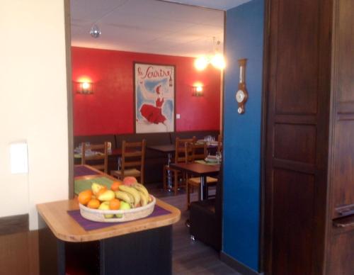 a room with a table with a bowl of fruit on it at Hôtel Bellevue Bagnoles Normandie in Bagnoles de l'Orne