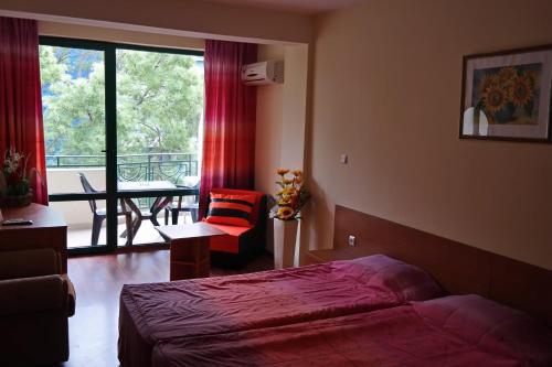 a hotel room with a bed and a balcony at Tanya Hotel in Sunny Beach