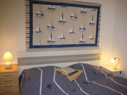ビューズムにあるAm Hafen ISのベッドルーム1室(壁に帆船の絵画付)