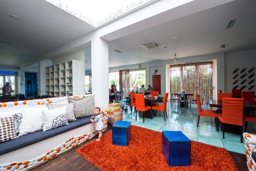 a child sitting on a red rug in a living room at La Locanda Del Mare in Paestum