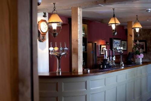 a bar with a counter with a clock on the wall at The Three Crowns in Chagford