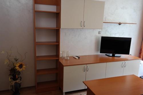 a room with a desk with a television and shelves at Tanya Hotel in Sunny Beach