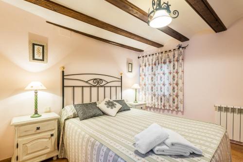1 dormitorio con cama y mesita de noche con lámpara en Casa La Carpintera en Royuela