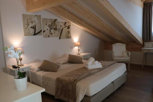 a bedroom with a large bed in a attic at Hotel RivaMia in Riva del Garda