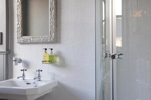 a bathroom with a sink and a mirror and a shower at The Three Crowns in Chagford