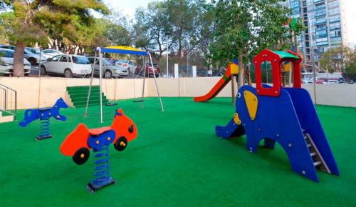 a playground with play equipment on the grass at Hotel Cabana in Benidorm