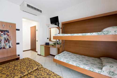 a bedroom with two bunk beds and a television at Hotel Kennedy in Lido di Jesolo