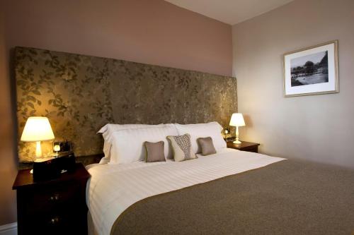 a bedroom with a large bed with two pillows at The Three Crowns in Chagford