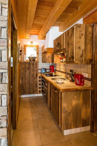 une cuisine avec des armoires en bois et un évier dans l'établissement Chalets Shangrila, à Saint-Michel-de-Chaillol