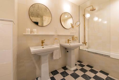 a white bathroom with two sinks and a mirror at Vincci The Mint in Madrid