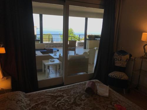 1 Schlafzimmer mit einer Tür, die auf einen Balkon mit Aussicht führt in der Unterkunft Taormina Chic Apartment in Taormina