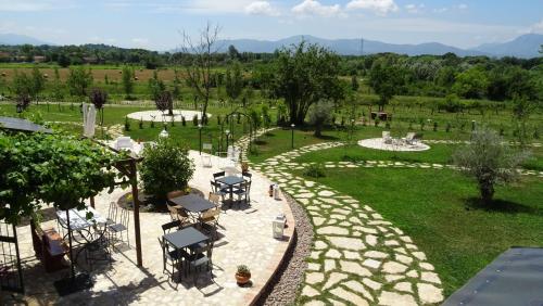 a patio with tables and chairs in a garden at AGRITURISMO iL PIOPPETO in Cassino