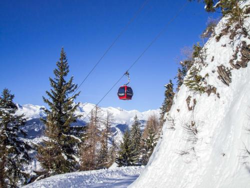 a ski lift flying over a snow covered mountain at Chalet Skilift in Rosswald