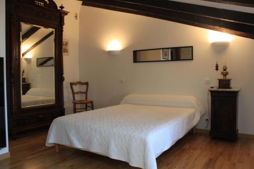 a bedroom with a bed and a mirror and a chair at A Spelunca in Speloncato