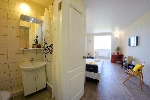 a bathroom with a sink and a bed in a room at 54a Tselinogradskaia Str at Alekseevka underground in Kharkiv