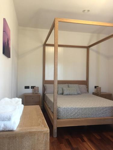 1 dormitorio con cama con dosel y suelo de madera en Villa Nieves, en Ibiza