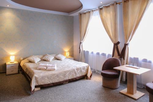 a bedroom with a bed and a chair and a window at Sosnowe Zacisze in Białystok