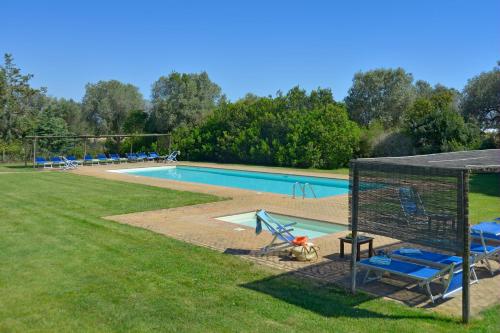 a swimming pool with blue chairs and a gazebo at Apartment I Fontanili in Pescia Romana