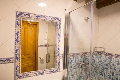 ヌエバ・デ・リャネスにあるCasa Nogalのバスルーム(鏡付きシャワー、ドア付)