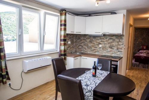 a kitchen and dining room with a table and chairs at Apartment Any in Mokošica
