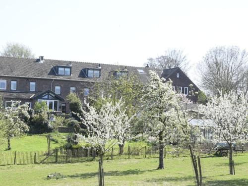 een groot huis met bomen ervoor bij Hoeve Schevey in Mechelen