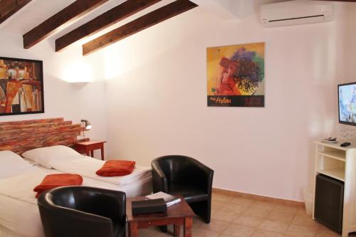 a room with two beds and a desk and a tv at Agroturismo Finca Sa Tanca in Cala d´Or
