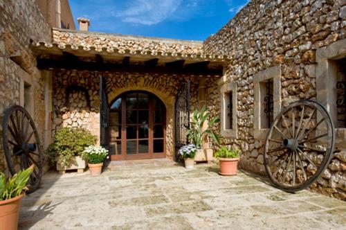 an entrance to a stone building with a large wheel at Agroturismo Finca Sa Tanca in Cala d´Or