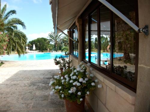 a building with a window with flowers next to a swimming pool at Agroturismo Finca Sa Tanca in Cala d´Or