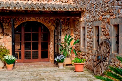 an entrance to a stone building with a door and a wheel at Agroturismo Finca Sa Tanca in Cala d´Or