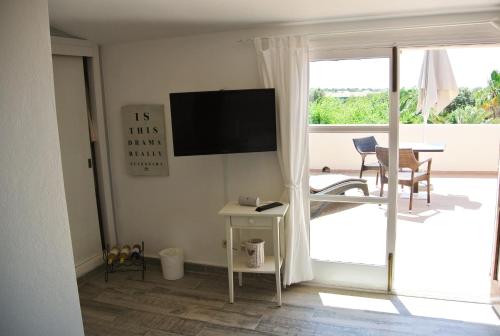a living room with a television and a sliding glass door at Agroturismo Finca Sa Tanca in Cala d´Or