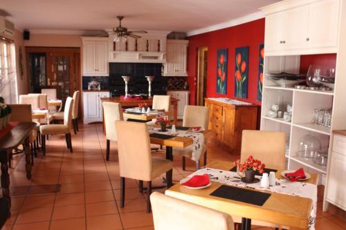 a kitchen and dining room with tables and chairs at Villa de la Rosa Klerksdorp in Klerksdorp