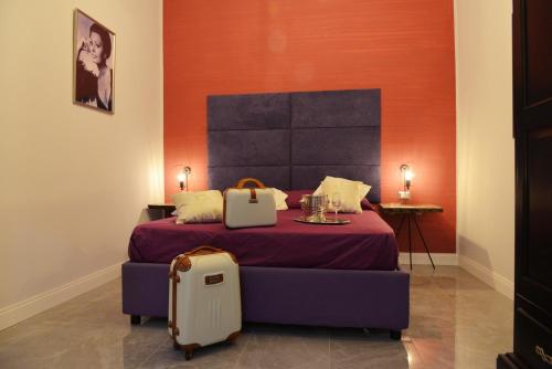 a bedroom with a bed with a suitcase next to it at Chiaia Roof in Naples