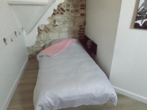 a bed in a room with a brick wall at Le gite des Menhirs in Mont-Saint-Éloi