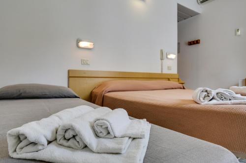 una camera con due letti con asciugamani di Hotel Smile a Rimini
