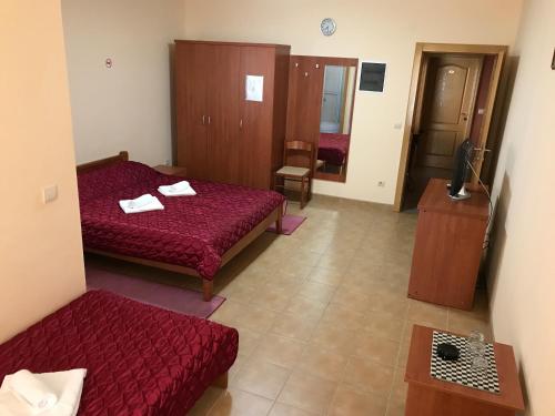 a hotel room with two beds and a couch at Villa Laguna in Sutomore